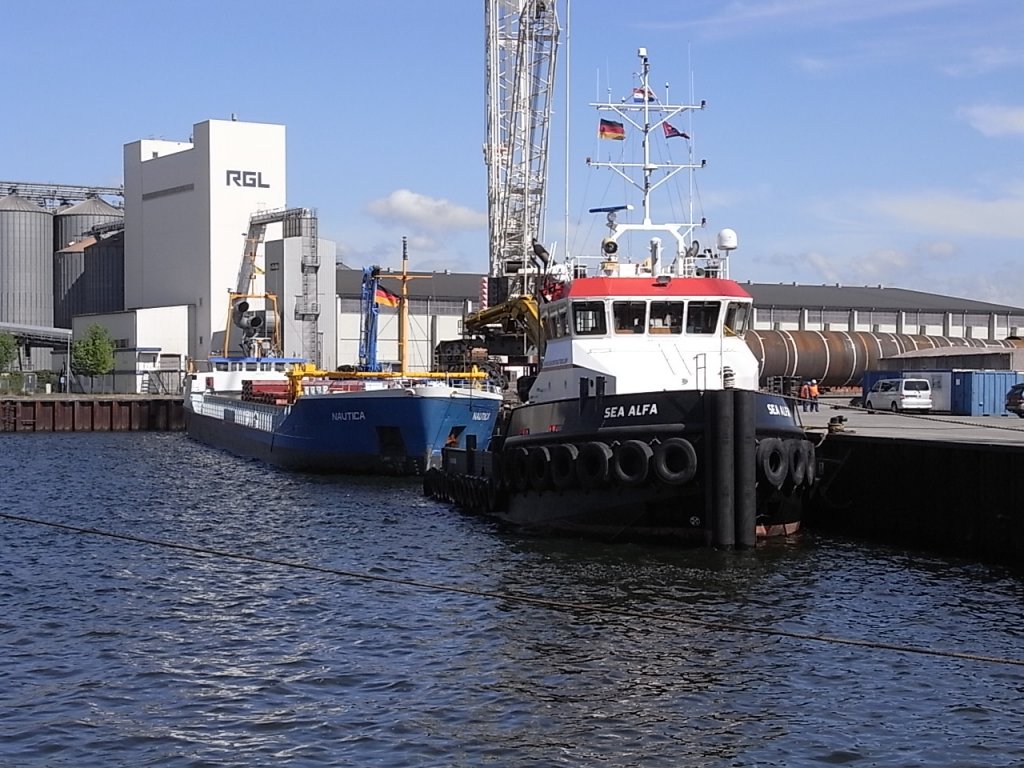 Schlepper,  SEA ALFA  kurz vor dem Auslaufen mit dem MS  Nautica  im Anhang. Hier am LP 10, im Rostocker Seehafen an der Pier des Grorohr-Werk. 