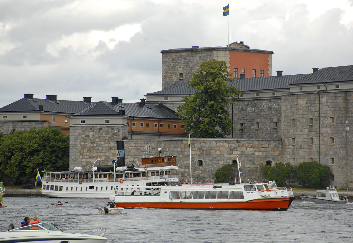 Das Fahrgastschiff »Daphne« vor der Vaxholm Festung im Stockholmer Scherenhof. Im Hintergrund ist das Dampfschiff »Norrskär« zu sehen. Aufnahme: 27. Juli 2017.