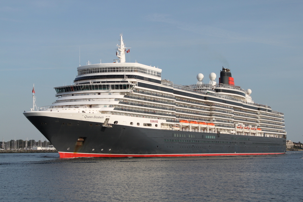 Die 294 m lange Queen Elizabeth der Reederei Cunard Line auf ihrem Seeweg von Stockholm nach Southampton beim Auslaufen am Abend des 22.08.2019 in Warnemünde.