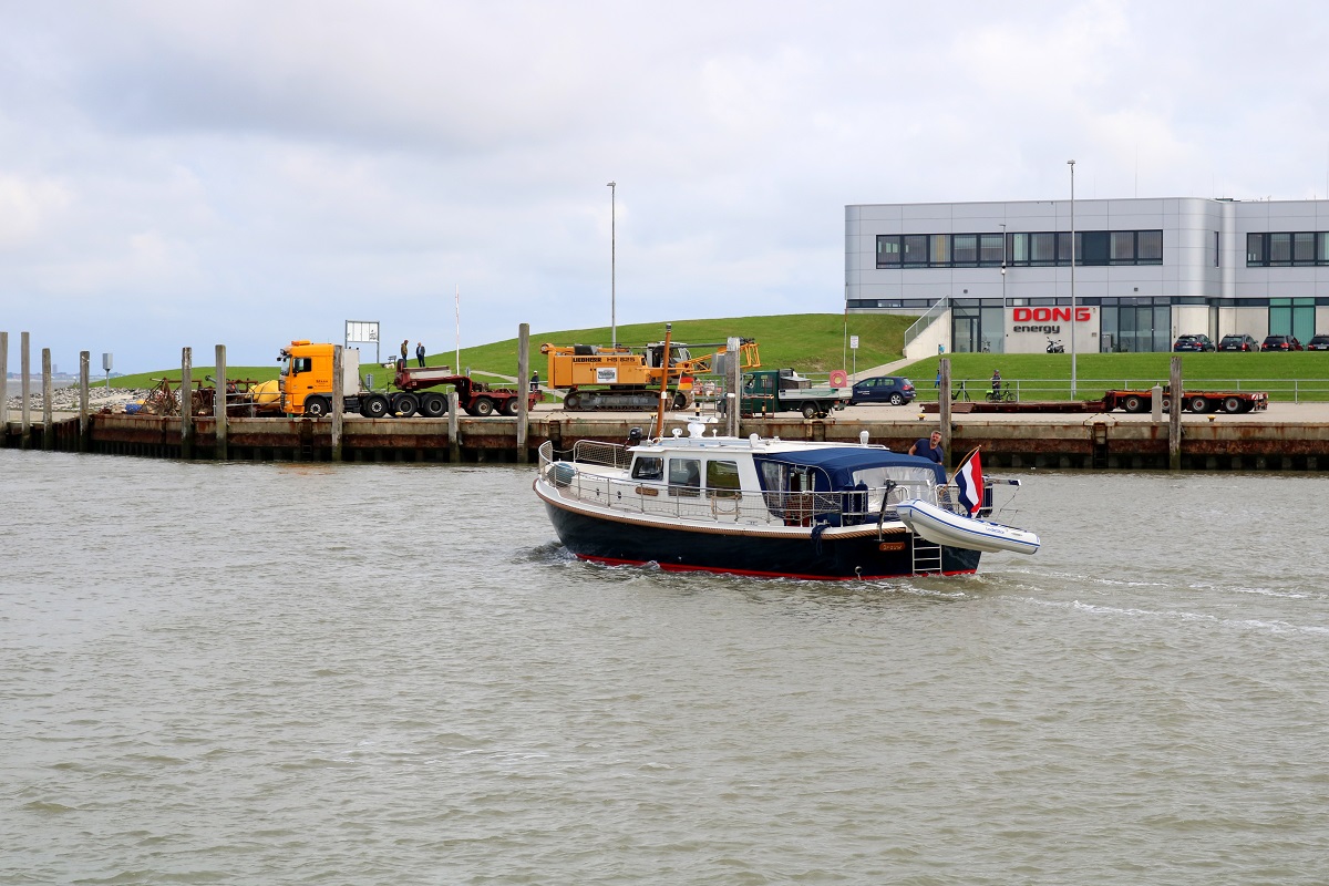 Motorboot  Grouw  läuft aus dem Norddeicher Hafen aus. Im Hintergrund ist das Gebäude von DONG Energy zu sehen. [25.7.2017 - 11:16 Uhr]