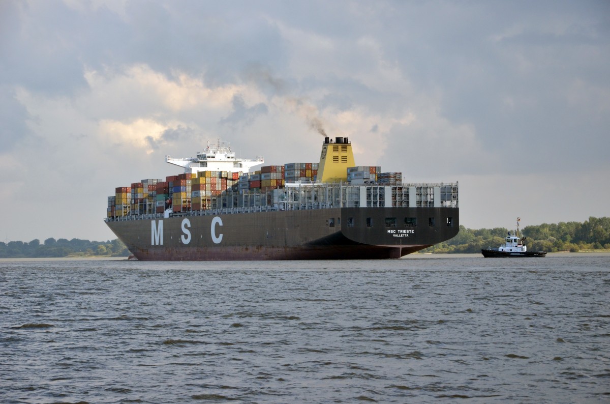 MSC Trieste  Containerschiff. Hier wird gerade hinten ein Schlepper angehngt. Heimathafen Valletta IMO: 9484479, Baujahr: 2011, Container: 13050 TEU, Lnge: 365.50 m, Breite: 48.40 m, Tiefgang: 15.50 m, Geschwindigkeit: 24.00 kn. In Wedel am 25.09.15  einlaufend  nach  Hamburg beobachtet