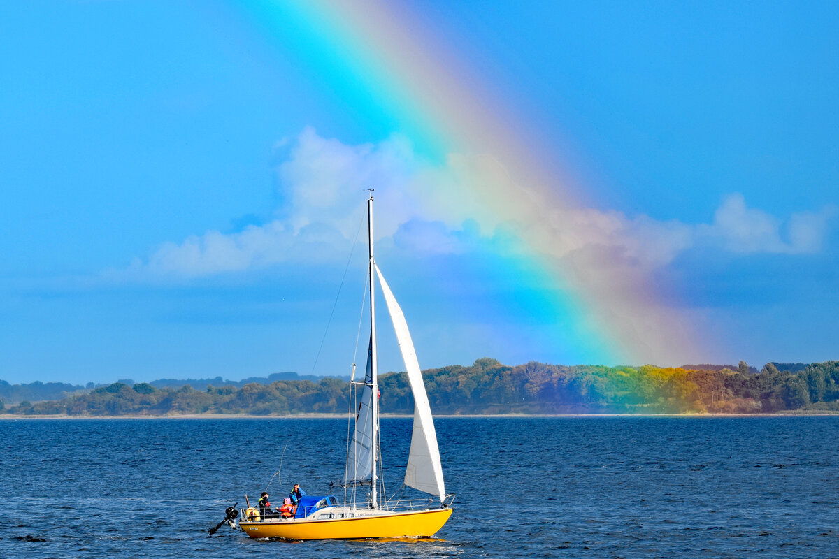 Segelboot am 02.10.2022 in der Ostsee vor Lübeck-Travemünde. Die Farben eines Regenbogens werten  das Bild optisch auf.