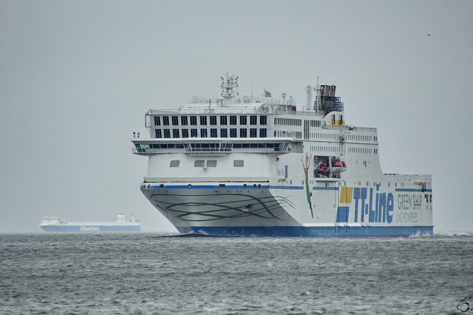 Das Fährschiff PETER PAN (IMO: 9880946) kommt hier im April 2024 gerade in Travemünde an, während im Hintergrund die FINNPULP (IMO: 9212644) noch ein paar Tage auf der Ostsee ausharren muss.