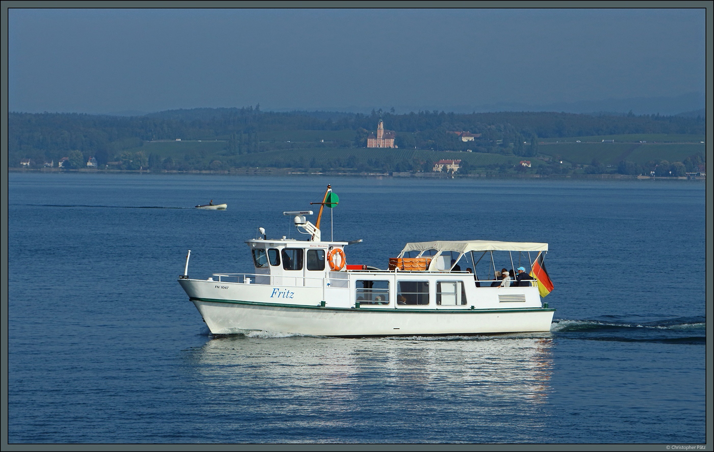 Zwischen Mainau und Meersburg pendelt in der Saison das kleine Motorschiff  Fritz . Am 06.10.2023 ist Mainau fast erreicht, im Hintergrund ist die Wallfahrtskirche Birnau zu sehen.