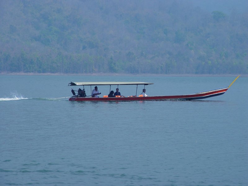 Auf einem Stausee in der Nhe der nordthailndischen Stadt Chiang Mai ist dieses Longtail Boot unterwegs. Diese Boote sind die einzige Verbindung zwischen der Hauptanlegestelle am See und den im See verankerten Hausbooten und Restaurantbooten