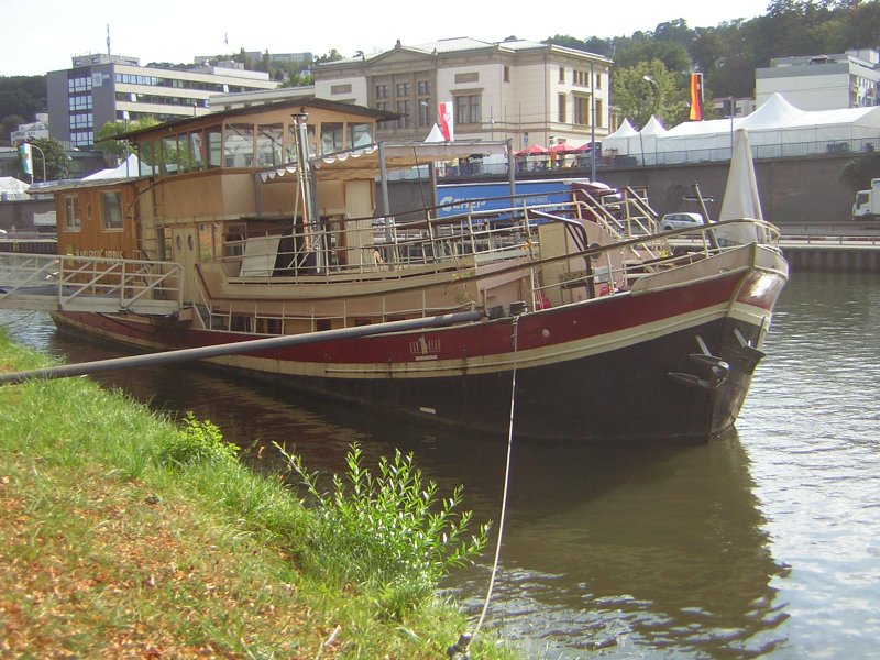 Dieses Foto zeigt ein Theater Schiff an seiner Anlegestelle. Das