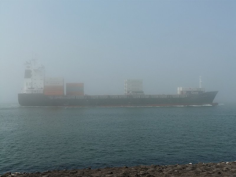 Was für ein Wetter. In dichtem Nebel verlässt dieser Frachter Was für ein Wetter. In dichtem Nebel verlässt dieser Frachter