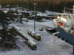 Die landinseln werden von Finnland versorgt. Zum Gtertransport auf der Inselgruppe werden Roadtrains eingesetzt, die mit LKW-Fhren transportiert werden. Das Foto zeigt die Verladung der Lastwagen-Zge im Fhrhafen Lngnes; 16.01.2001