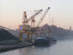 Im Hafen Castrop-Rauxel-Habinghorst (Rhein-Herne-Kanal) wird MS Linquenda im Eiltempo durch zwei Liebherr Hafenportalkrne der Firma Luck KG Hafenbetrieb am Morgen des 05.11.03 mit Sand beladen.