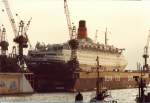 QUEEN ELIZABETH 2  IMO 6725418 im Oktober 1992 in Dock 11 von Blohm&Voss, Hamburg / 
Cunard Line / bei John Brown& Co, Clydebank, Nr. 736 / 18.4.1969 Ablieferung / BRT 65863 / La. 293,53, B 32,01, Tg. 9,87m, / 2 Satz Getriebeturbinen, 110.000 PS, 2 Prop. 28,5 kn / 1986/87 bei Lloyd Werft, Bremerhaven auf dieselelektrischen Betrieb umgebaut, neun 9-Zyl. MAN/B&W, 95.650 kw, 2 E-Motore, 86770 kW, 28,5 kn / BRT 66.450 / 2.10.1992 nach Reparatur bei Blohm&Voss, Hamburg, BRZ 69.053  / 12.1994 BRZ 70.327 / 27.11.2008 Auerdienststellung / Umbau zum Hotel-Schiff /
 (Scan vom Foto)