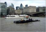 Schiffe auf der Themse vor der Skyline von City of ...