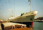 K�mos Connie, IMO 6511908 mit Flagge Antigua and Barbuda, bei Umschlagsarbeiten im Wolgaster Stadthafen im Sommer 2000. Dort wurde in Prahme der Binnenreederei d�nischer Weizen f�r Berlin geladen. Im Hintergrund, an der Pier festgemacht,das Schubboot 2434 der DBR AG.
