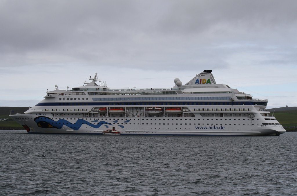AIDAcara ist auf dem Weg durch die Gewsser des Nordatlantiks. Hier liegt sie am 12.7.2012 vor Lerwick auf Reede. 