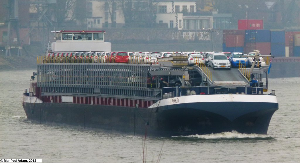 Am 26.02.2012 fhrt das RoRo-Schiff Tossa (ENI 02321654) in Hhe von Krefeld auf dem Rhein zu Berg. Lnge: 125,56 m, Breite: 12,05 m, Tiefgang: 1,80 m, Tonnage: 700 t. Vor dem Umbau als RoRo-Schiff lief die Tossa als Containerschiff Diona mit einer Tonnage von 3548 t und einem Tiefgang von 3,45 m. Es konnte 232 TEU laden.