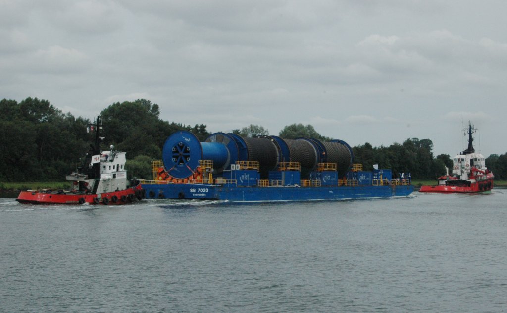 Am 27.07.2011 Kabelrollen auf dem NOK beobachtet. Hier kommen lange Seekabel fr die Anbindung der Offshore-Windparks, von nkt.  Auf bis zu 500 000 Volt sind die grten Produkte des Hochleistungskabel-Herstellers nkt cables ausgelegt. Der deutsche Windpark Baltic 2 (ehemals Kriegers Flak) wird in der Ostsee ca. 32 km nrdlich der Insel Rgen gelegen sein. 80 Windmhlen werden eine Flche von 27 Quadratkilometern bedecken mit einer Kapazitt von 288 MW. Rund 340.000 Haushalte werden Strom aus dem Windpark, der voraussichtlich im Jahr 2013 in Betrieb genommen wird, erhalten. Der Schlepper  Storesund hinten, und der Schlepper Eurosund vorn.