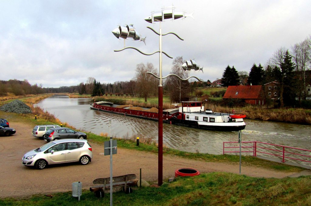 An dem Parkplatz am ELK bei der Kronsforder Brcke, kann man die Schffsbewegungen in Ruhe sogar von der Bank am Symbol der drei silisierten Fische, die den alten Stecknitzkanal symbolisieren, betrachten. Auf dem ELK fhrt die GMS Paula Richtung Lbeck... Aufgenommen: 18.12.2011