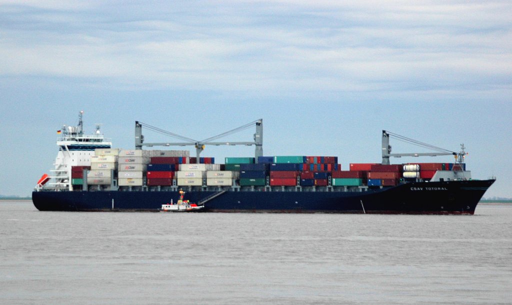 Das Containerschiff  CSAV  TOTORAL  (IMO: 9415296) von Hamburg auf dem Weg nach Chile passiert gerade Brunsbüttel. Baujahr: 2008, Länge  211m, Breite  32m , 12m Tiefgang  und bringt es auf  21,6 Knoten. Noch hängt das Lotsenboot dran um den Lotsen von Bord zu holen.