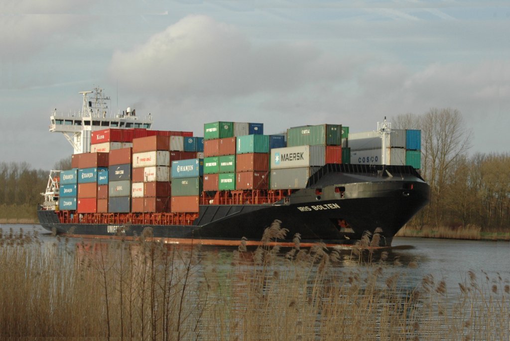 Das Containerschiff Iris Bolten / Hamburg (IMO: 9369007) Richtung Brunsbttel vor der Eisenbahnhochbrcke in Hochdonn. Aufgenommen am 07.04.2011.

