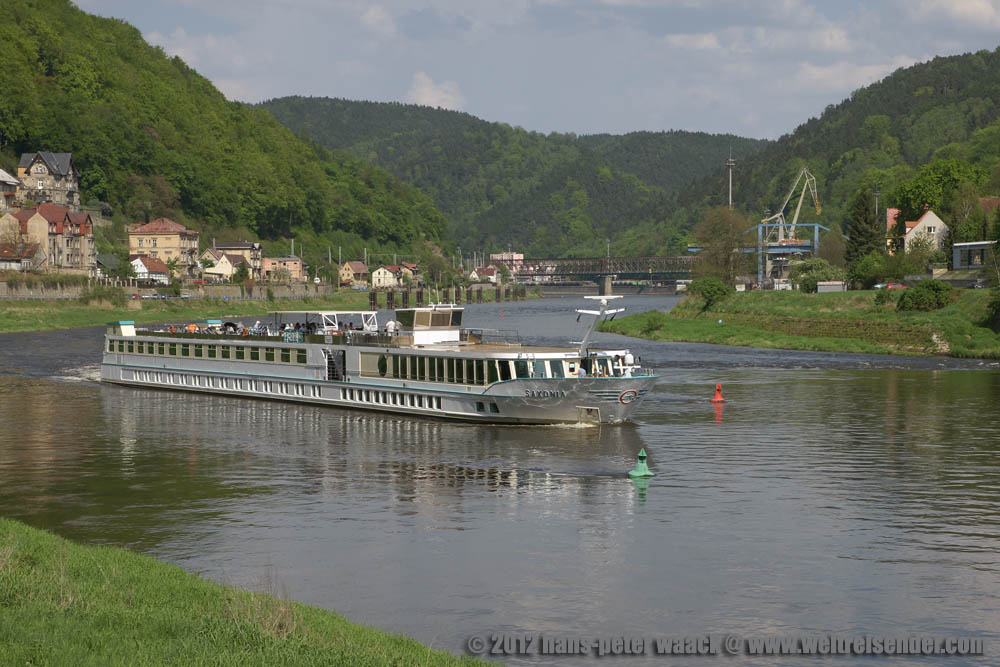 Das Motorschiff Saxonia passiert die schmale Durchfahrt neben einem  Riff  in Decin.