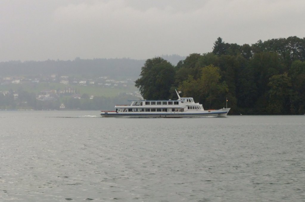 Das Motorschiff  Weggis  bernachtet momentan fast tglich in Brunnen. Am 24.9.2010 wurde die abendliche Rckfahrt dorthin (Kurs 27) allerdings durch den einsetzenden starken Regen etwas getrbt, wie diese Aufnahme vor Hertenstein zeigt. 