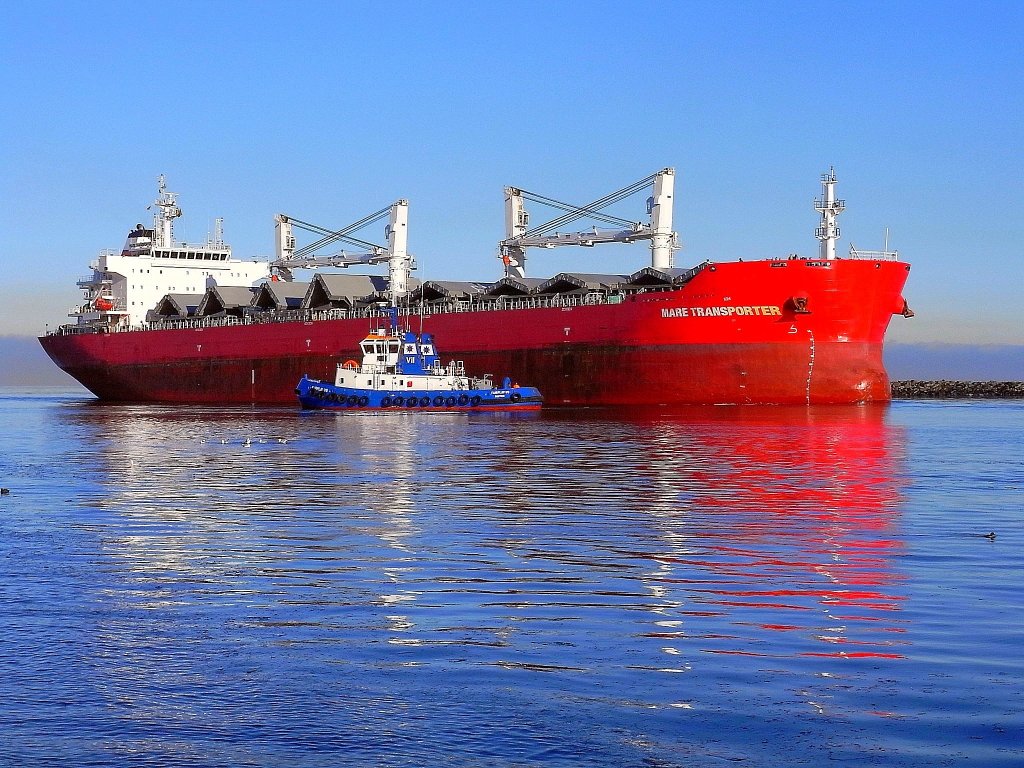 Das MS  MARE TRANSPORTER , HH Majuro, hier einlaufend in den Rostocker Seehafen.
Der Schlepper  FairPlay VII  geht in Stellung um als Heckschlepper aktiv zu werden.
Schiffstyp: Bulk Carrier mit Doppelboden, L 189,99 m, B 32,26 m, T 12,80 m