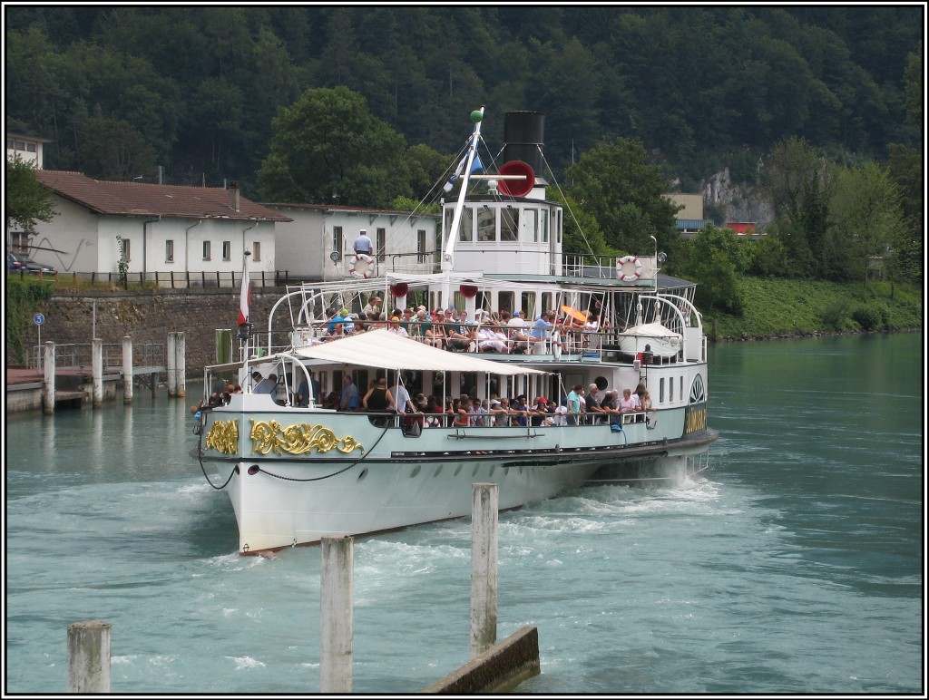 Der historische Raddampfer  Blmlisalp  verlsst am Nachmittag des 21.07.2010 die Anlegestelle in Interlaken West fr eine neue Tour ber den Thuner See. Alle Schiffe fahren von Interlaken West aus zunchst rckwrts durch den Stichkanal bis zum Thuner See, auf dem dann gewendet wird. 