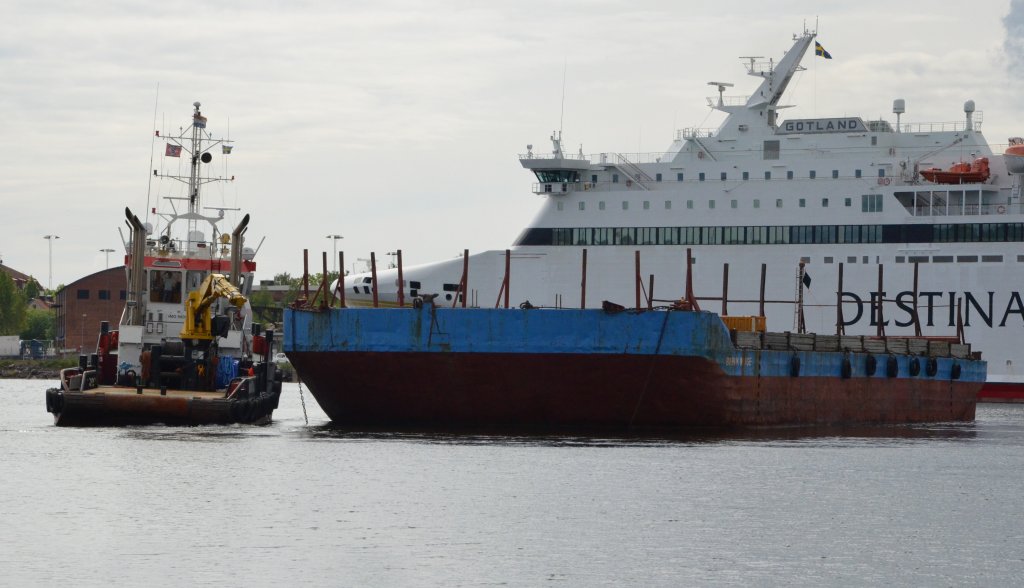 Der Schlepper Sea Foxtrot versucht die Brevik  Barke im Hafenbecken zu drehen um diese wegzuschleppen. In Oskarshamn am 29.05.2012 beobachtet. Die Fhre Destination-Gotland  ,,Visby‘‘ im Hintergrund.