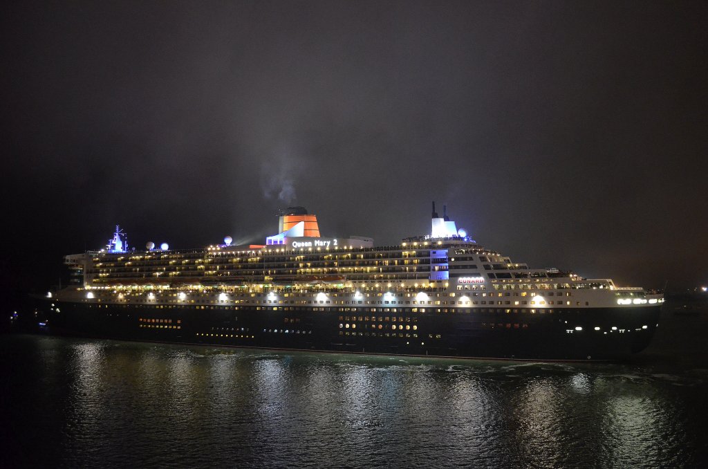 Die Queen Mary 2 IMO-Nummer:9241061 Flagge:Bermuda ex Grobritannien Lnge:345.0m Breite:41.0m Tonnage:151.400BRZ Geschwindigkeit:30Knoten Besatzung:1254 Passagiere:2620 Kabinenanzahl:1310 Baujahr:2003 Bauwerft:STX France,Nantes Saint-Nazaire Frankreich verlsst strahlend erleuchtet am 05.06.12 den Hafen von Southampton aufgenommen von der Queen Elizabeth.