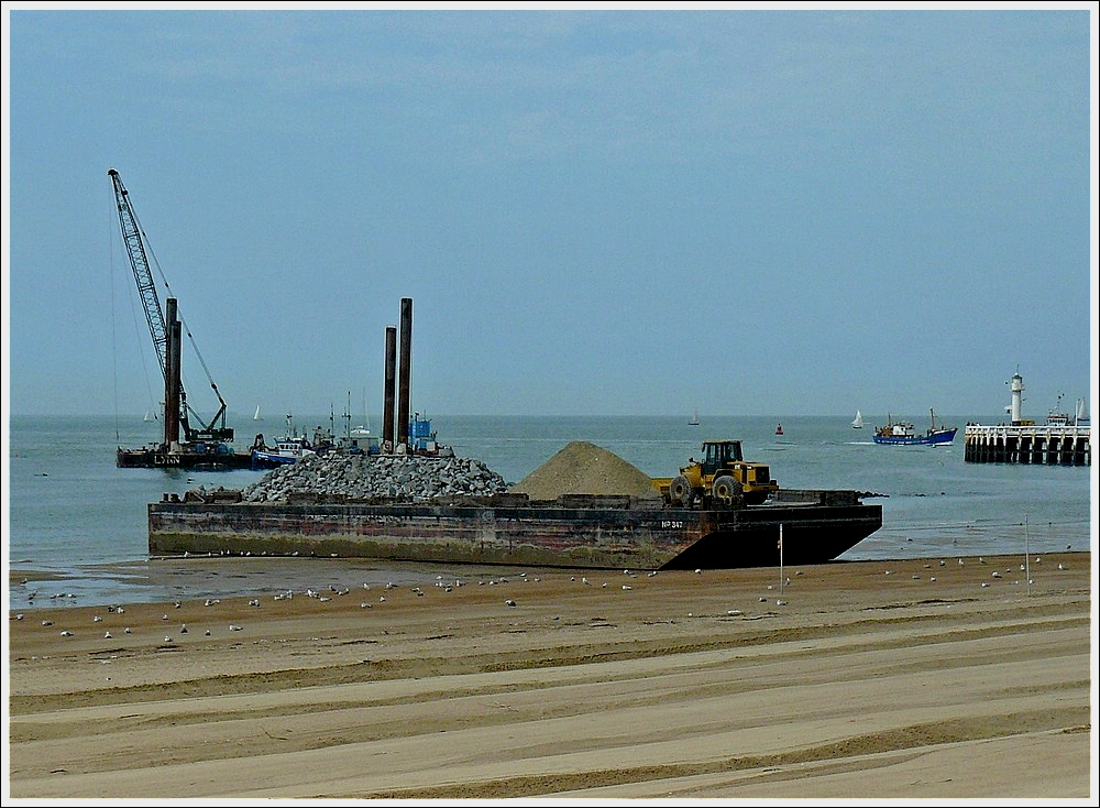 Ein beladener Schleppkahn am Strand bei der Hafeneinfahrt von Oostende. 10.07.2010