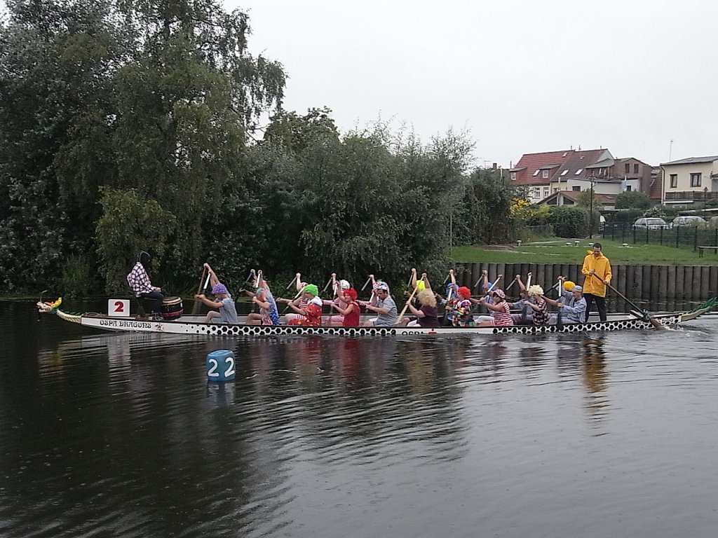 Ein Drachenboot mit gemischter und kostmierter Besatzung beim traditionellen Drachenbootrennen zum 15.Brckenfest in Schwaan auf der Warnow.