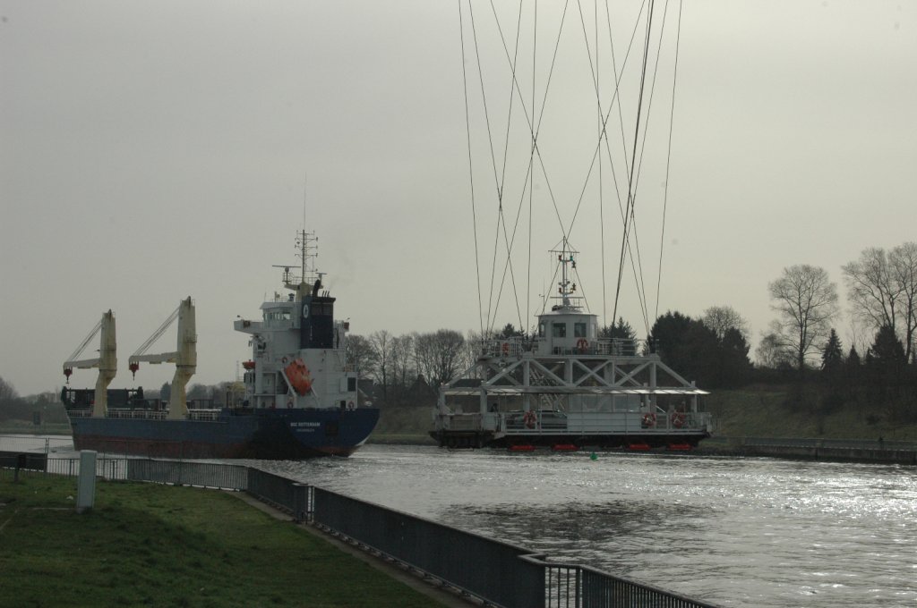Ein Frachtschiff, OSC Rotterdam  (IMO: 9277333) mit Heimathafen Groningen. Fotografiert auf dem Nord-Ostsee-Kanal bei Rendsburg. Ein schner Anblick mit der Schwebefhre unter der Eisenbahnhochbrcke  am 11.04.2011.