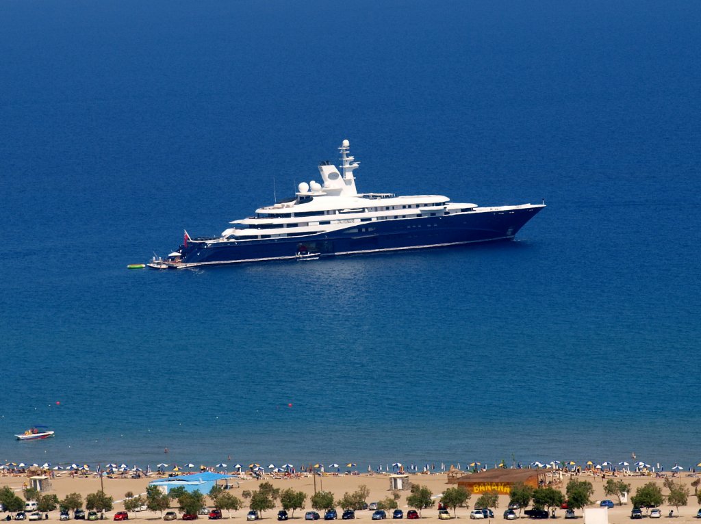 Eine richtig groe Megayacht am 10.06.2010 vor dem Tsambikastrand auf Rhodos (GR). Es handelt sich um die  Al Mirqab , Eigner ist der Emir von Katar. Die Mae:3000 BRT, Lnge 133 m, Breite 20 m. Angetrieben wird das Schiff von fnf kombinierte Diesel-Elektromotoren mit je 2.800 Kilowatt Leistung. Gebaut wurde die Yacht 2004-2008 von 700 Spezialisten aus ganz Europa bei Peters Schiffbau in Wewelsfleth in Schleswig-Holstein. Das Schiff gewann den Titel  Motoryacht des Jahres 2009  und ist zur Zeit die Nr.7 in der Liste der lngsten Motoryachten. Selbstverstndlich besitzt die Jacht einen Hubschrauberlandeplatz inklusive eines Eurocopter 155 mit einer Hchstgeschwindigkeit von 327 km/h.