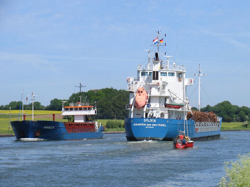 Frachtschiff-Begegnung auf dem NOK: in Richtung Kiel: die mit Holz beladene SYLVIA, KRIMPEM aan den YSSEL, Niederlande, IMO: 9166467, Lnge 108m, Breite 15m; Baujahr 1999 in Rumnien bei SEVERNAV SHIPYARD, SEVERIN - und in Richtung Brunsbttel: PERSEUS; 05.06.2010 
