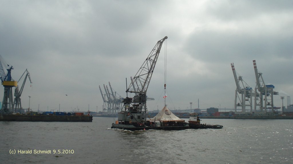 HHLA I 001 am 9.5.2010, Hamburg, Elbe, Hhe Vorhafen, am Hafengeburtstag mit Gsten und geschoben vom Schlepper Taifun /
Schwimmkran / BRT 375 / La 26,47 m, B 15,1 m, Tg 1,4 m / 2 MWM-Diesel, je 154 PS, 2 Prop. / Ausleger: Hubhhe max. 32,1 m, Ausladung: max. 17,4 m / Tragfhigkeit bei:  5 m Ausladung 30 t, bei 17 m Ausladung 10 t, Deckslast 100 t / 1928 bei Deutsche Werft, Hamburg, Krantyp: Kampnagel Dreh- Wippkran / Eigner+Betrteiber: Hamburg Museum, Museumshafen velgnne /
