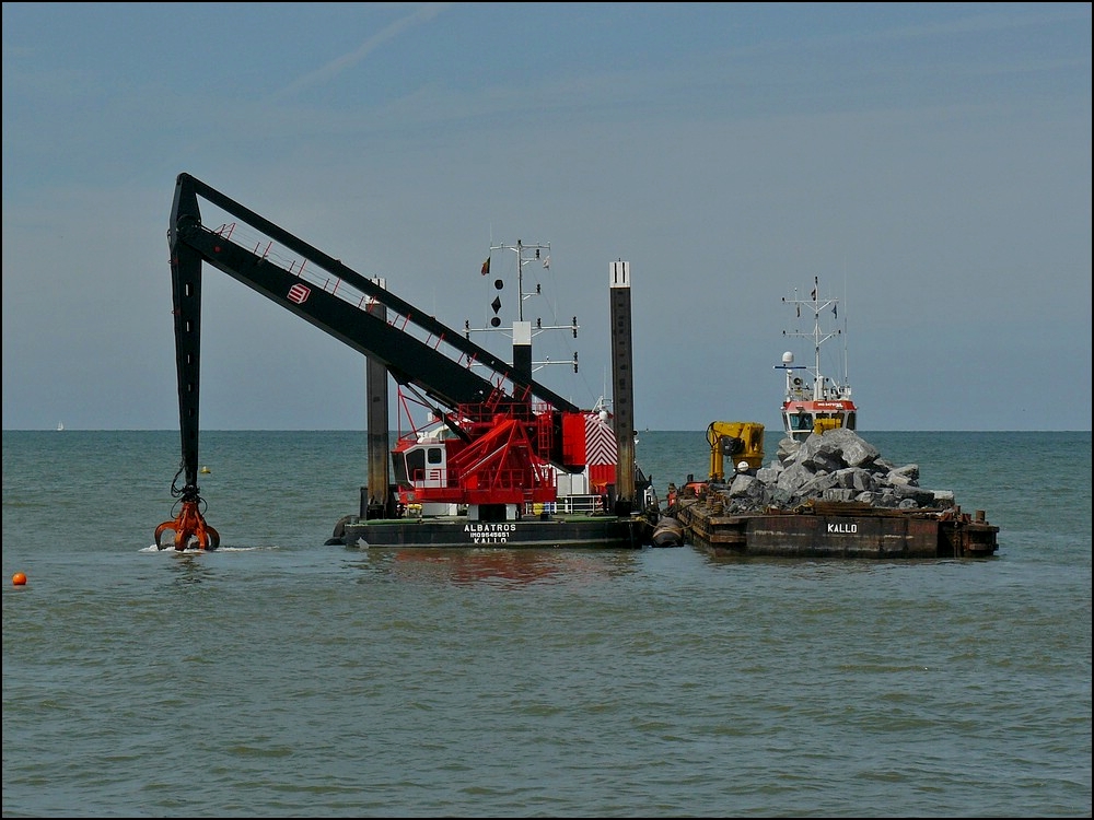 Hier positionniert der Schwimmkran einen grossen Felsbrocken im Wasser in der Nhe der Hafeneinfahrt von Oostende.  11.08.2010