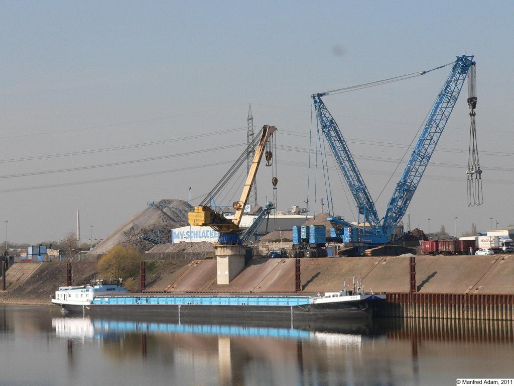 Im Wendebecken des Rheinhafen Krefeld liegt am 24.03.2011 das MSG-Binnenschiff Main. Im Hintegrund der 200 t Last hebende Kran Big Rocky (gelb) und ein schwerer Raupenkran der Fa. Felbermayr (blau).
