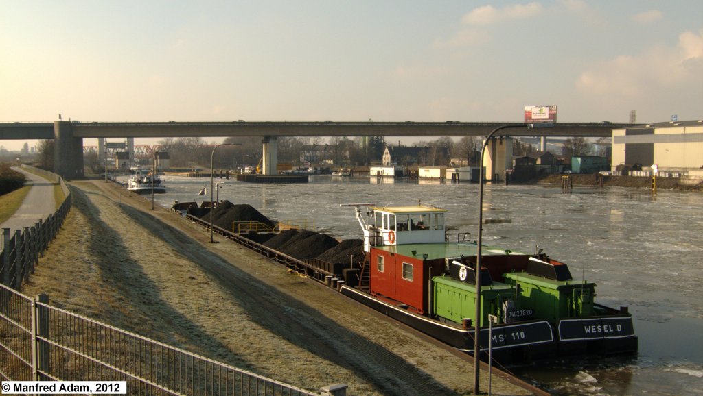 Klappschute MS 110 (ENI 04027620) wartet am 04.02.2012 im Rhein-Herne-Kanal vor der Schleuse Duisburg-Meiderich. Länge: 85,00 m, Breite: 9,50 m, Tiefgang: 2,93 m, Tonnage: 1599 t.