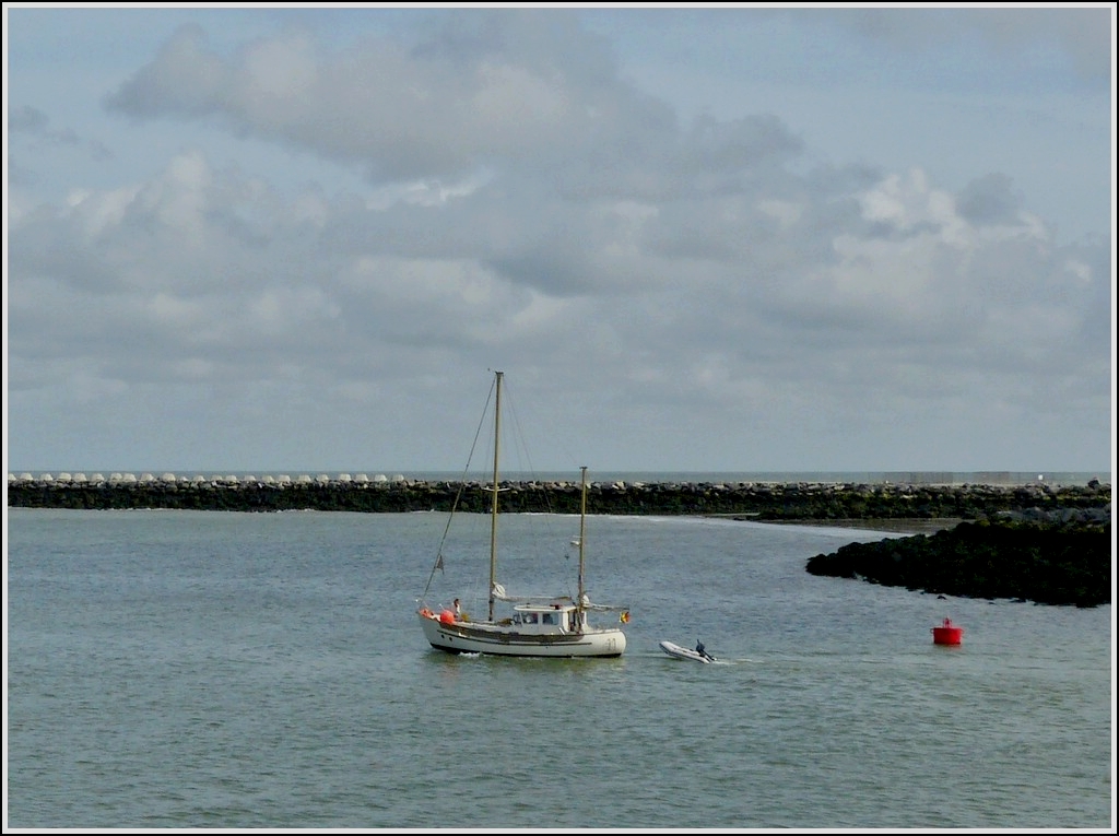Mit Motorkraft verlsst dieses Segelboot den Hafen von Oostende mit einem Schlauchboot im Schlepp.  22.08.2012