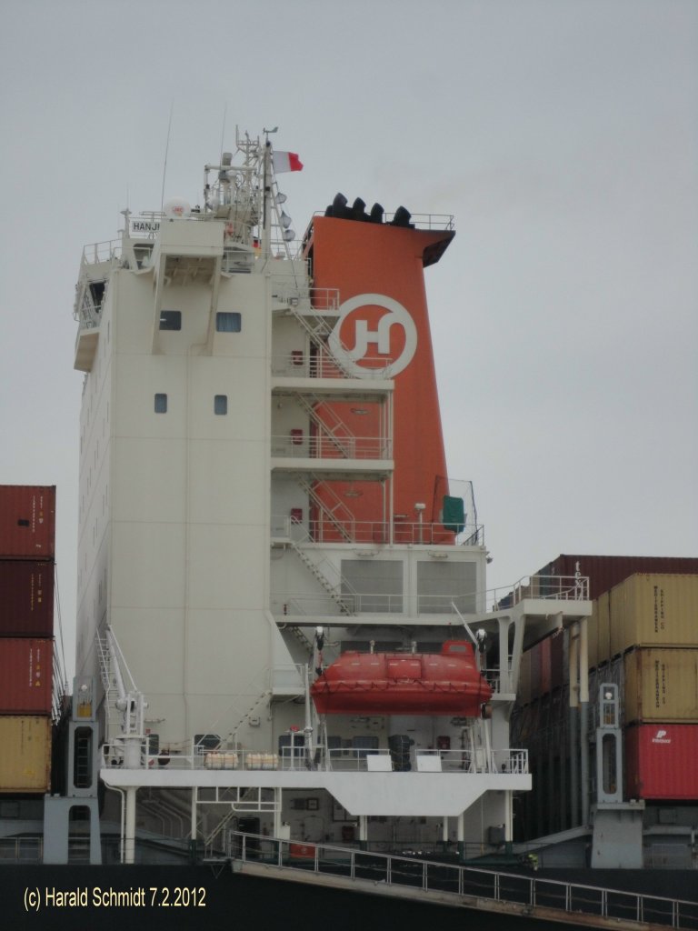 Schornsteinmarke der HANJIN CHONGQING (IMO 9347449) am 7.2.2012, Hamburg, Elbe, einlaufend vor dem Bubendeyufer /
Containerschiff / BRZ 74.962 / La 304 m, B 40 m, Tg 14,2 m / TEU 6622, Reefer 600 / 1 Diesel, 68382 kW, 26,5 kn / 2008 bei Hyundai, Ulsan, Sdkorea / Flagge: Panama / Besitzer + Manager: Hanjin Shipping /
