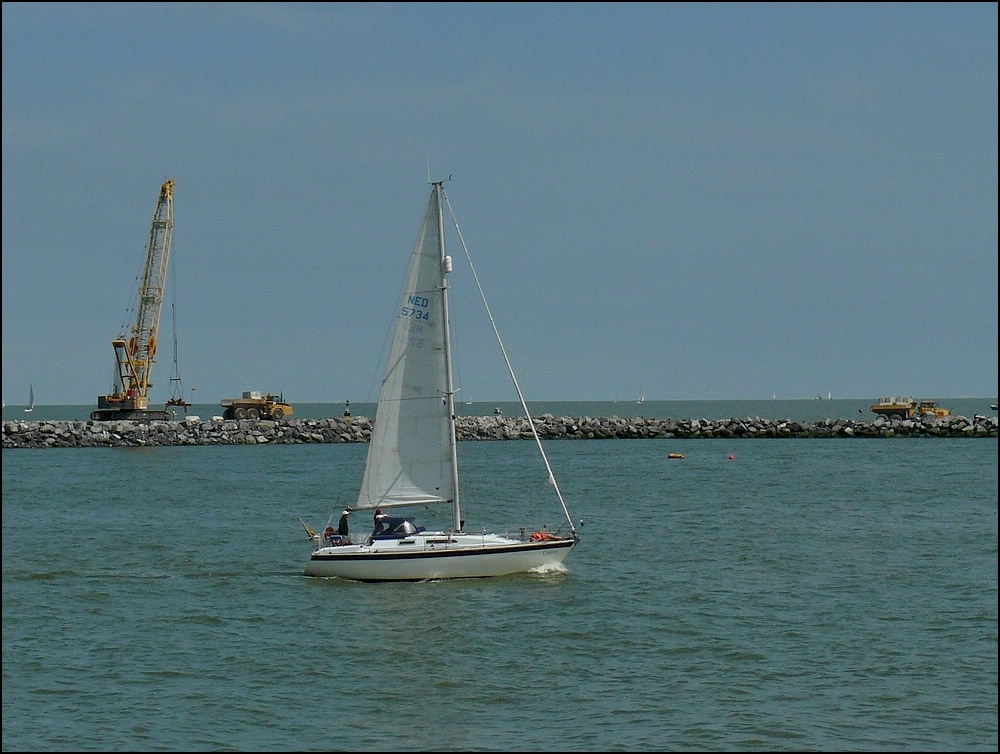 Segelschiff CROESO in der Hafeneinfahrt von Oostende, im Hintergrund sieht man die Schwerlasttransporter und den Raupenkran bei den Arbeiten am Hafen von Oostende.  11.08.2010