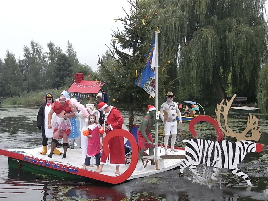 Viele lustige Gestallten auf einer selbstgebauten schwimmenden Kutsche.  Das Vehikel war Teilnehmer am Bootscorso anlsslich des 15.Brckenfest  in Schwaan auf der Warnow.