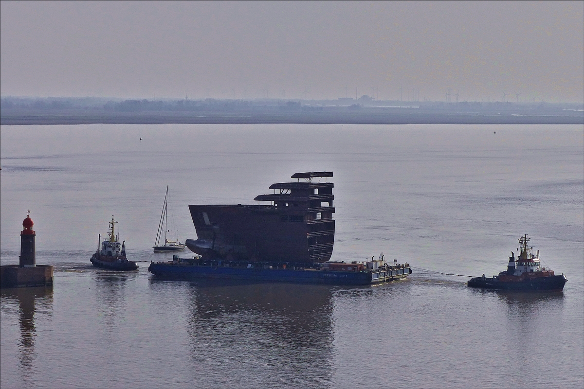 . Der Schlepper „Wolf“ zieht den Schwerlast Ponton „OFFSHORE BHV 1“ beladen mit einem Schiffsteil, aus der Einfahrt des Fischereihafens hinaus auf die Weser in Richtung der Hafendock Anlagen von Bremerhaven. Der Schlepper „Mars“ hilft durch ziehen und schieben das schwierige Gefährt in der richtigen Spur zu halten.   08.04.2018  (Jeanny)