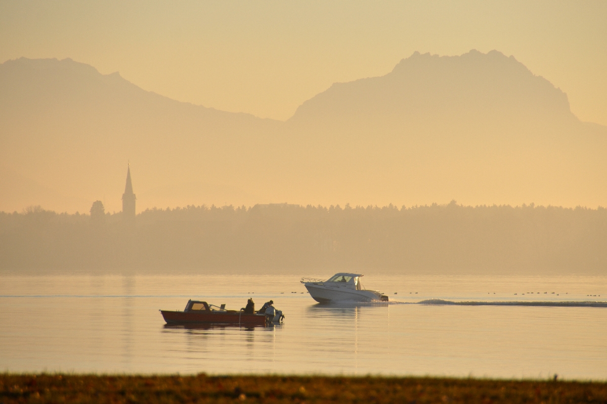 Abendstimmung mit Freizeitbooten am Bodensee vor Hörbranz (Vorarlberg): Der Kirchturm gehört zum Kloster Mehrerau, der Gebirgsstock im Hintergrund sind die Drei Schwestern (2011-11-27)