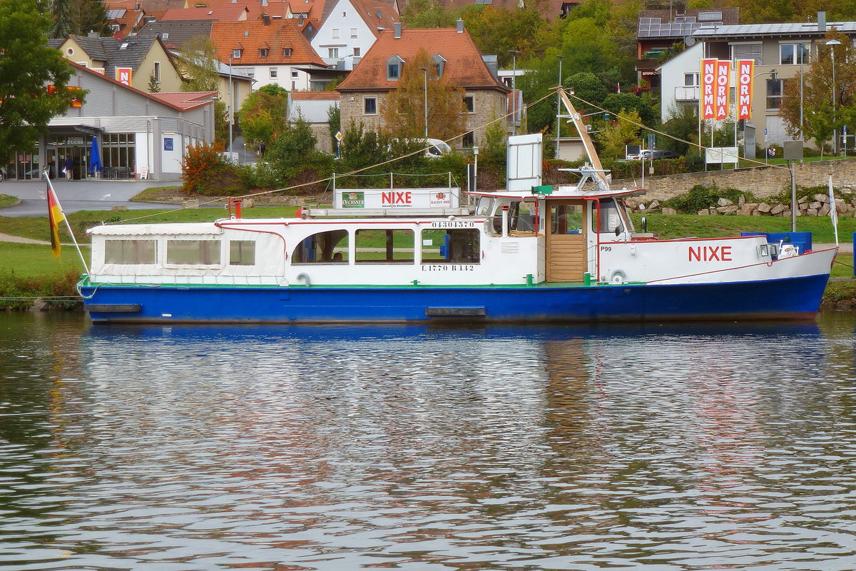 Altstadtfähre und Ausflugsschiff NIXE am Mainufer bei Ochsenfurt.  1959 gebaut, war sie danach als Rheinfähre zwischen Remagen und Linz unterwegs, bis sie ab 2007 den Fährdienst in Ochsenfurt versah. Aufnahmedatum: 09.10.2020.