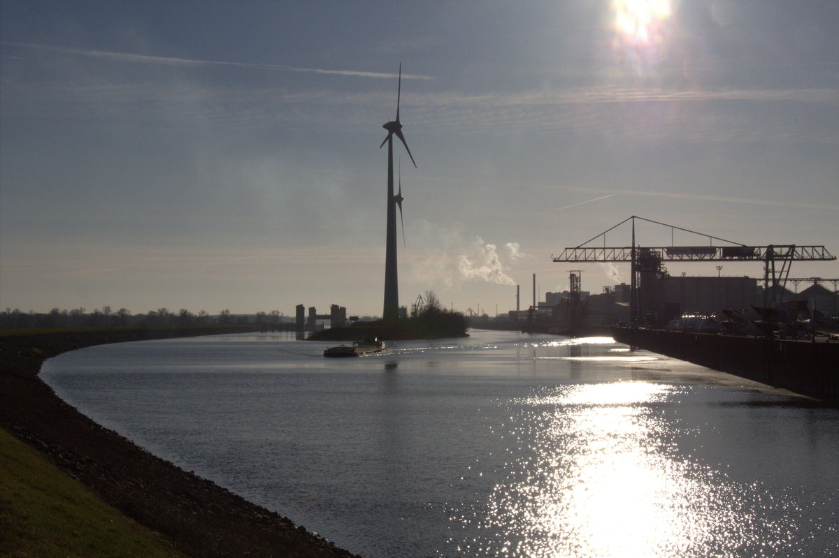 Am 21.01.2020 ist bei herrlichem Sonnenschein / Gegenlicht dieser Blick auf den Rothenseer Verbindungskanal mit der Niedrigwasserschleuse im Hintergrund entstanden. In der Bildmitte ist die Steinkopfinsel mit den 2 Windrädern und dem aus dem Hafen Magdeburg kommenden GMS Nelly (02314263) zu sehen. Rechts der Zweigkanal und das Hanse-Terminal.    