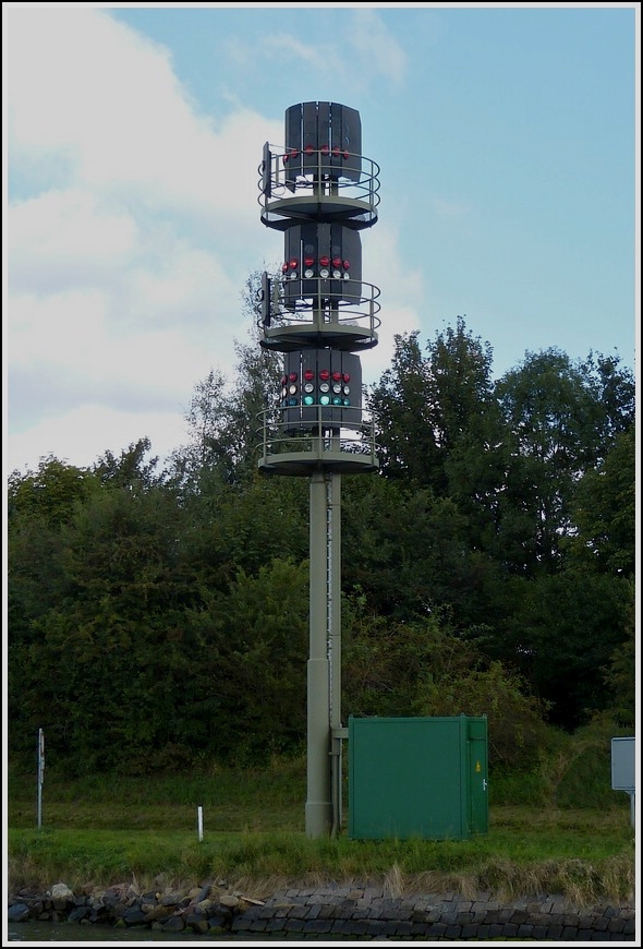 Ampelanlage auf dem Nord- Ost- See Kanal. Die Ampel kann auf den 3 Lichtebenen mit acht verschiedene Signalbildern geschaltet werden.  Es gibt 12 Weichen (Passierstellen fr groe Schiffe) mit solchen Ampelanlagen auf dem Nord- Ost- See Kanal. Aufgenommen am 18.09.2013 nahe Sehestedt. 

Die Schiffe sind je nach Lnge, Breite, Tiefgang und Ladung in 6 Verkehrsgruppen unterteilt. 

Schaltbilder der Ampelanlage:  Grn  freie Fahrt fr Alle  /  Rot  Rot  Rot,  Alle Fahrzeuge Stopp  /  Rot Weiss  Rot,  Stopp fr Schiffe ab Verkehrsgruppe 2 /  Rot Stopp fr Fahrzeuge ab VG 3 / Rot Rot Stopp fr Fahrzeuge ab VG 4  / Rot Rot Weiss  Stopp fr alle Fahrzeuge ab der VG 5 /  Rot Weiss Weiss  Stopp fr alle Fahrzeuge der VG 6 /  Rot Weiss  Stopp fr Schleppverbnde und Gefahrguttransporter
