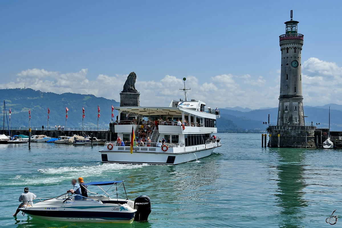 Anfang Juli 2017 verlässt das Fahrgastschiff LINDAU, während an Bord des Motorbootes TILLI relaxt wird.