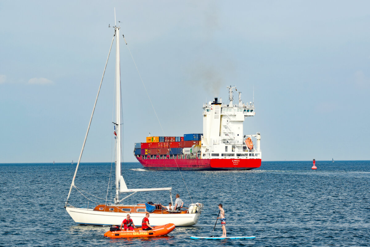 Besatzung eines DLRG-Bootes weist einen Stand up-Paddler an, die Gefahrenzone (Fahrwasser-Bereich für Seeschiffe) zu verlassen. Ostsee vor Lübeck-Travemünde, 13.08.2021
