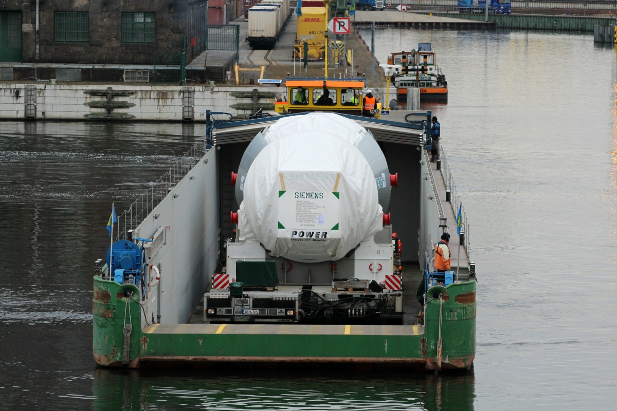 Blick auf die Ladung des RoRo-GSL's Ursus (04810440) am 16.02.2016 im Berliner Westhafen. SB Birk B (05801510) ist die schiebende/ziehende Einheit. Zu sehen ist eine Siemens-Gasturbine auf einem Goldhofer-Modul. 