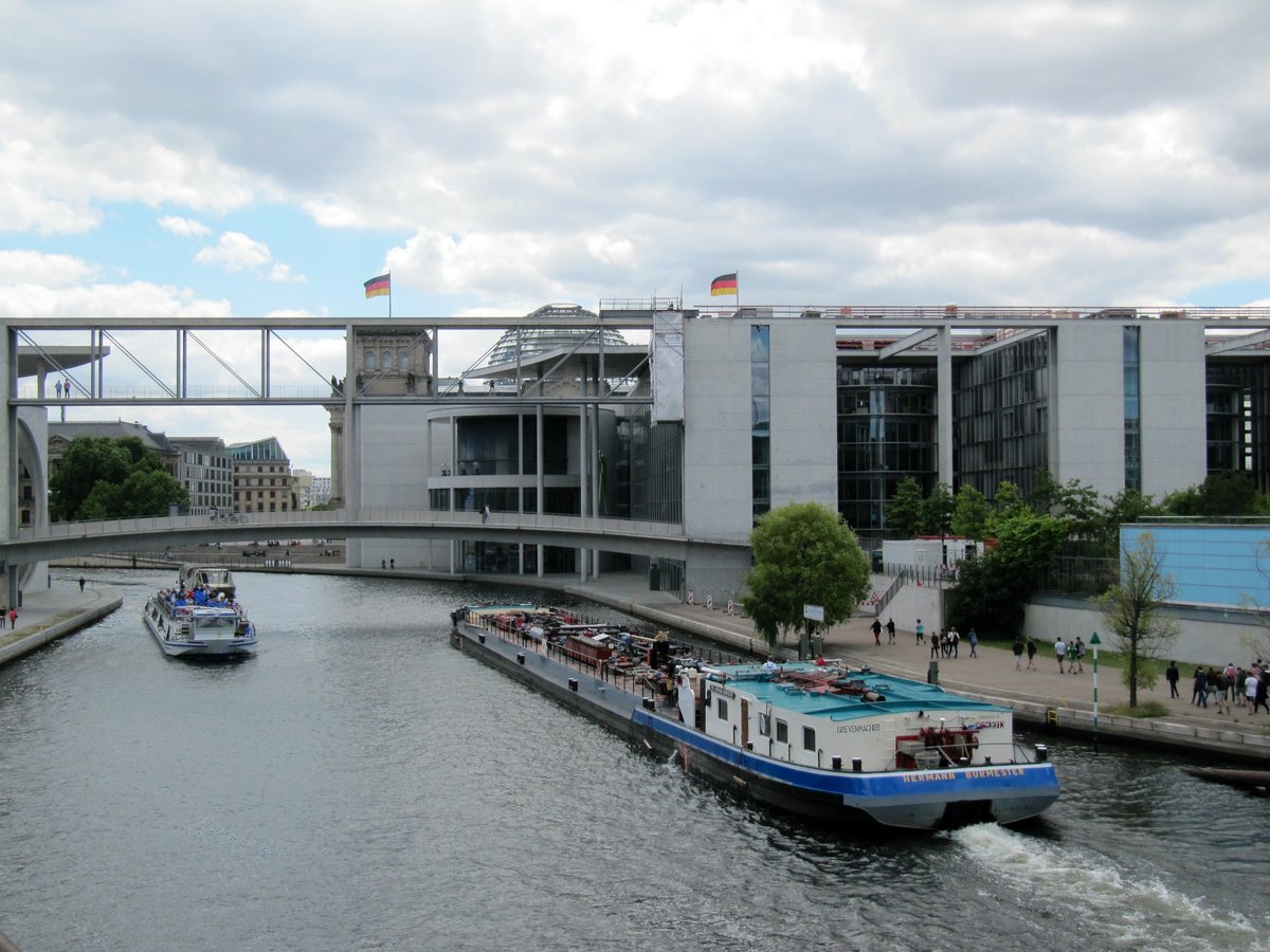 Blick auf Spree und Teile des Paul-Löbe-Hauses am 07.07.2016 im Berliner Regierungsviertel. Hinter dem Paul-Löbe-Haus ist das Reichstagsgebäude mit dem Deutschen Bundestag. Das TMS Hermann Burmester (08043013) und ein FGS unterqueren die Verbindungsbrücke Marie-Elisabeth-Lüders-Haus (links / nicht im Bild) und Paul-Löbe-Haus.